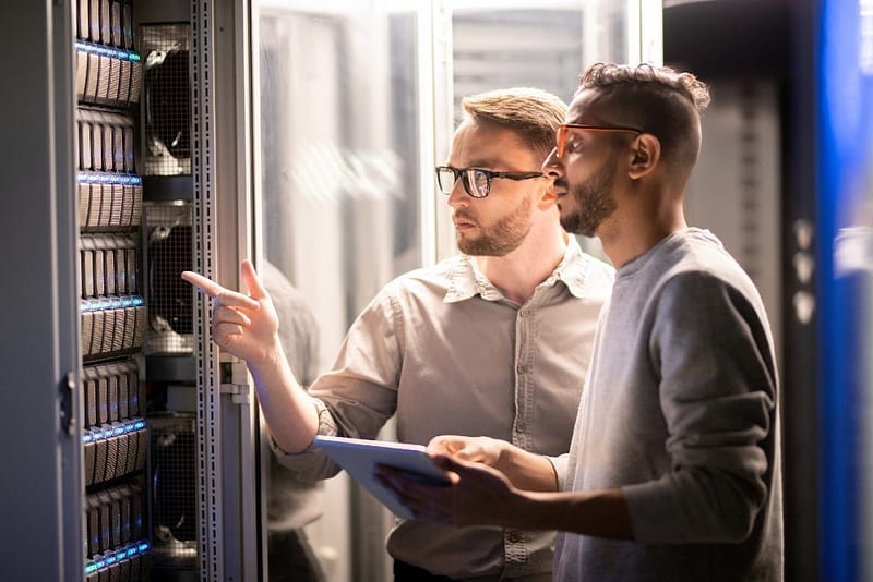 Two man looking at a server rack